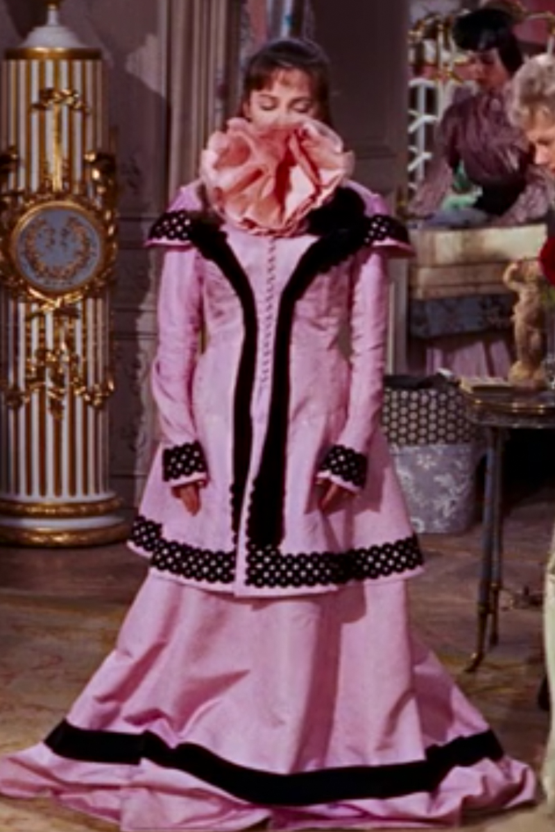Leslie Caron as Gigi wearing a pink and black dress in the 1958 film "Gigi."