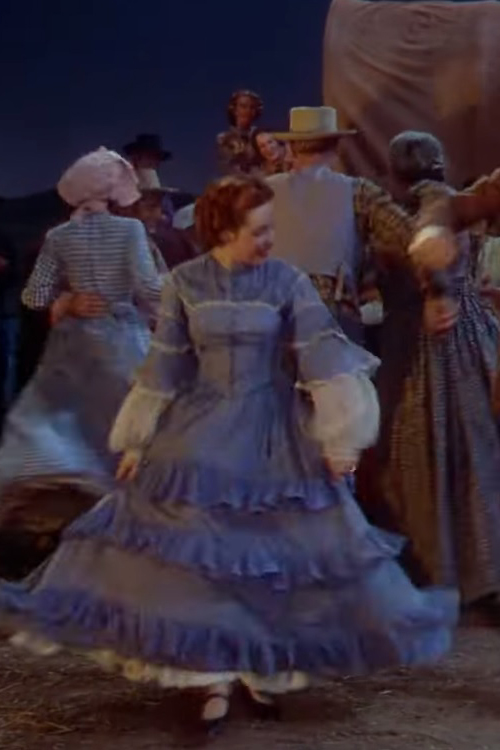 An extra wearing a blue ruffled gown in the 1944 film "Can't Help Singing."