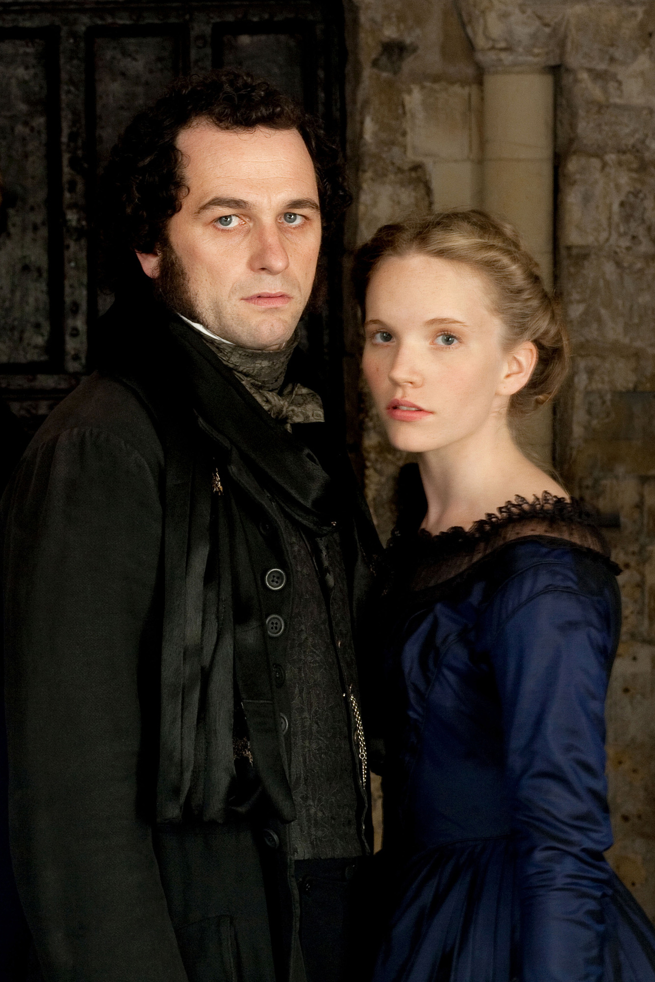 Tamzin Merchant as Rosa Bud wearing a dark blue gown in the 2012 mini-series "The Mystery of Edwin Drood."