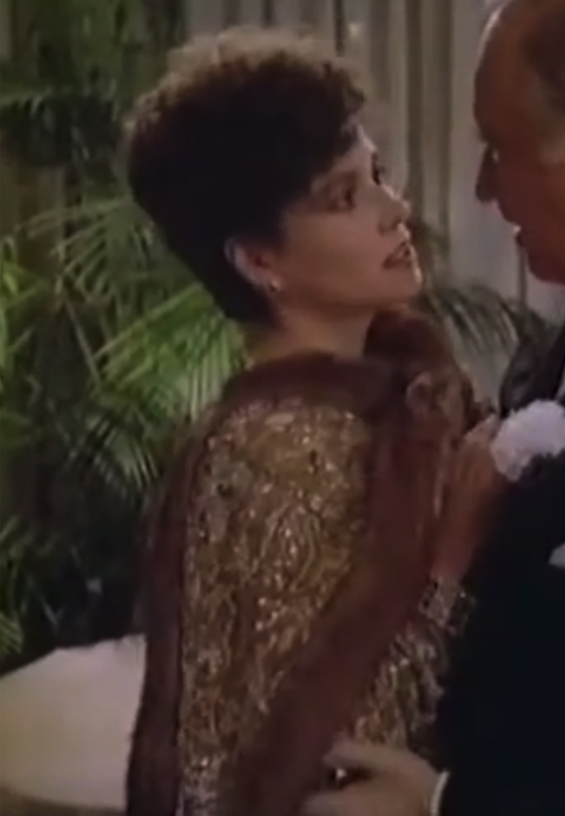 Barbara Hershey as Lili Damita wearing a gold bejeweled gown with fur edging in the 1985 film "My Wicked, Wicked Ways."