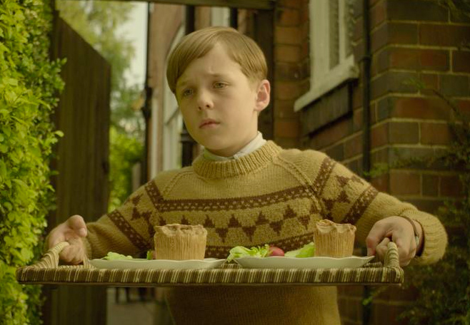 Oscar Kennedy as young Nigel Slater wearing a tan and brown sweater in the 2010 film "Toast."