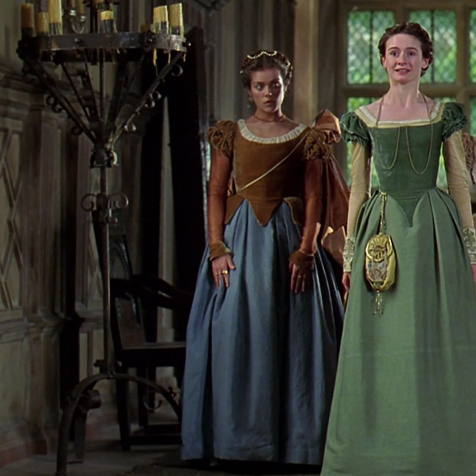 An extra as a lady in waiting wearing a brown and blue gown in the 1998 film "Elizabeth."