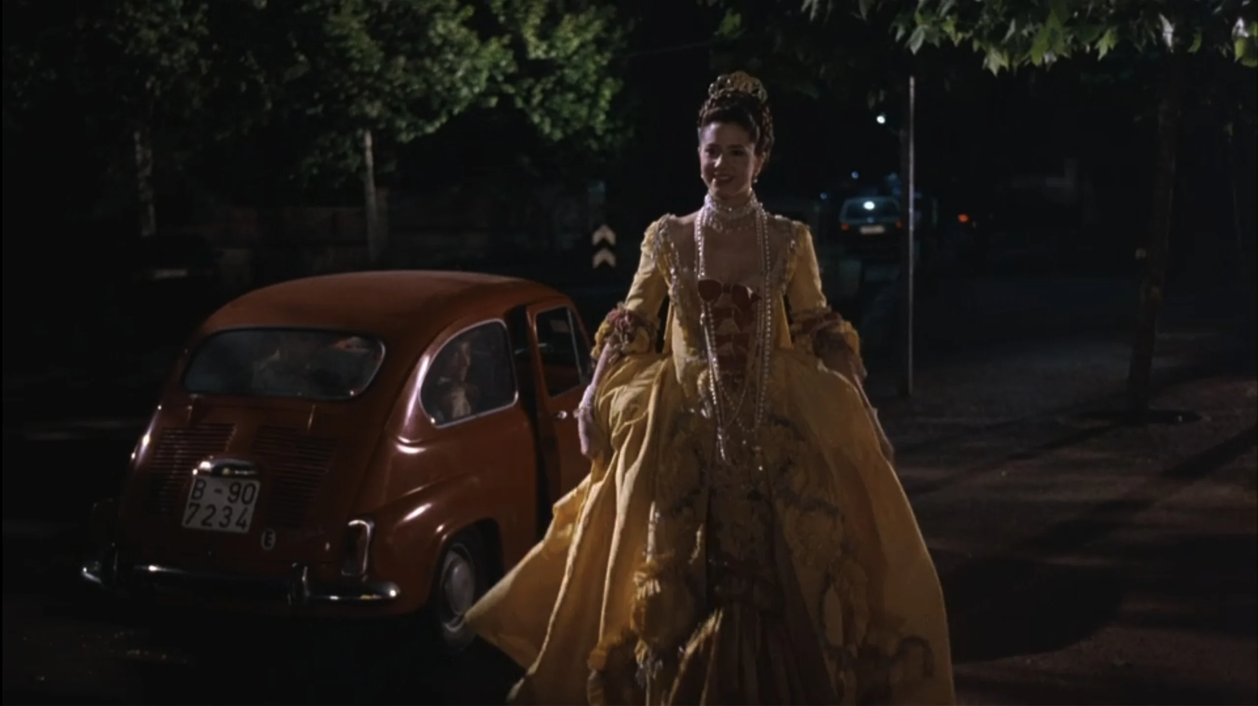 Mira Sorvino as Marta Ferrer wearing a yellow robe à la française with burgundy échelle in the 1994 film "Barcelona."