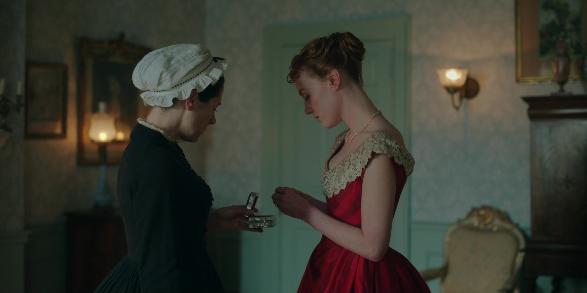 Harriet Slater as Clara Trenchard wearing a striped red gown decorated with lace in the 2024 series "Belgravia- The Next Chapter."