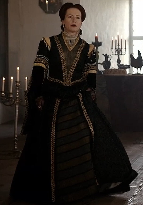 Ulrike Krumbiegel as Edeltraud wearing a black and gold gown in the 2013 film "Märchenperlen: Die goldene Gans."