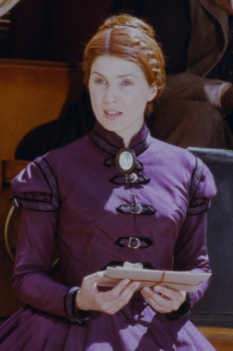 Sadie Frost as The Governess wearing a purple dress with black detailing in the 1999 film "Presence of Mind."