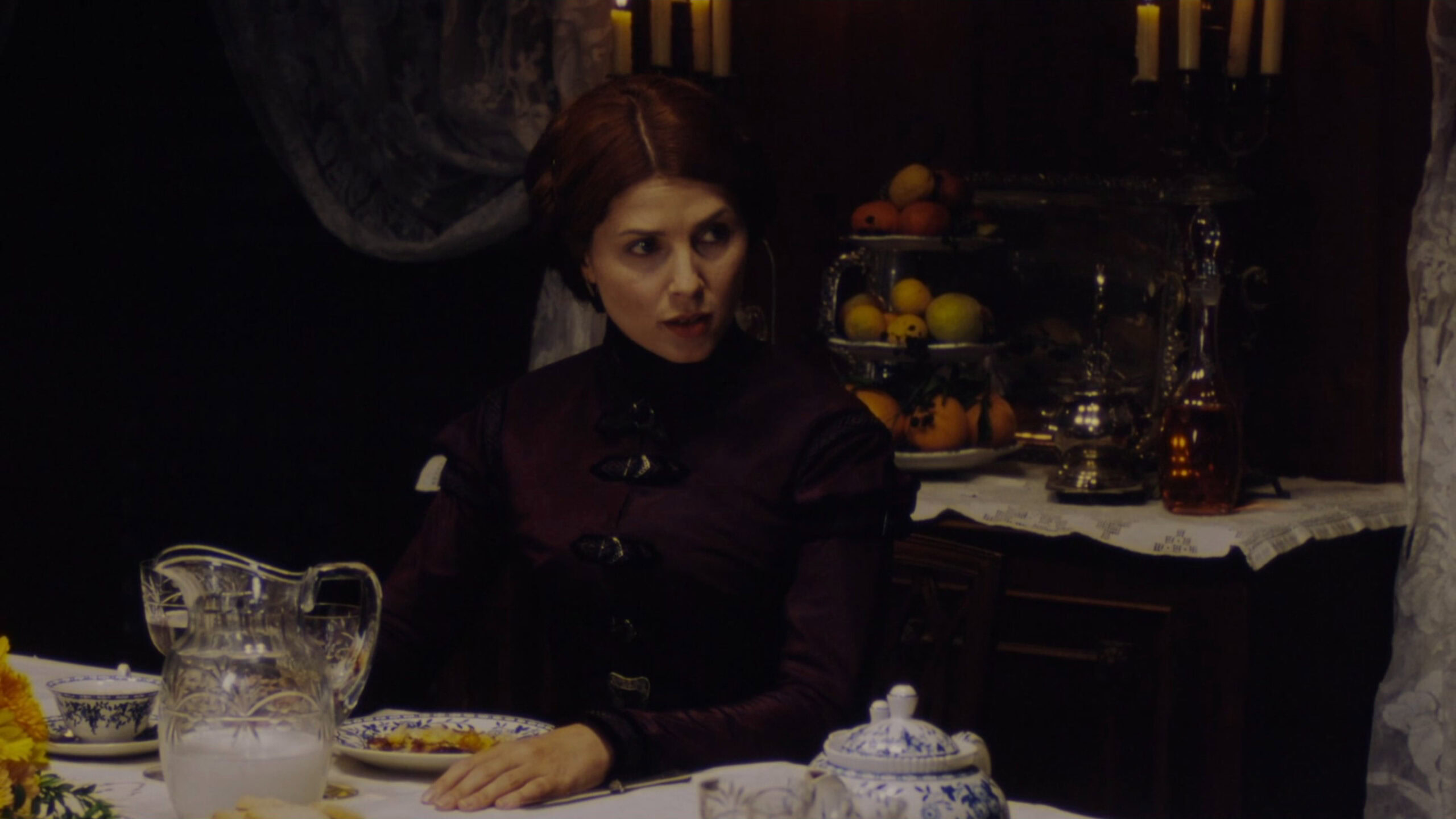 Sadie Frost as The Governess wearing a purple dress with black detailing in the 1999 film "Presence of Mind."