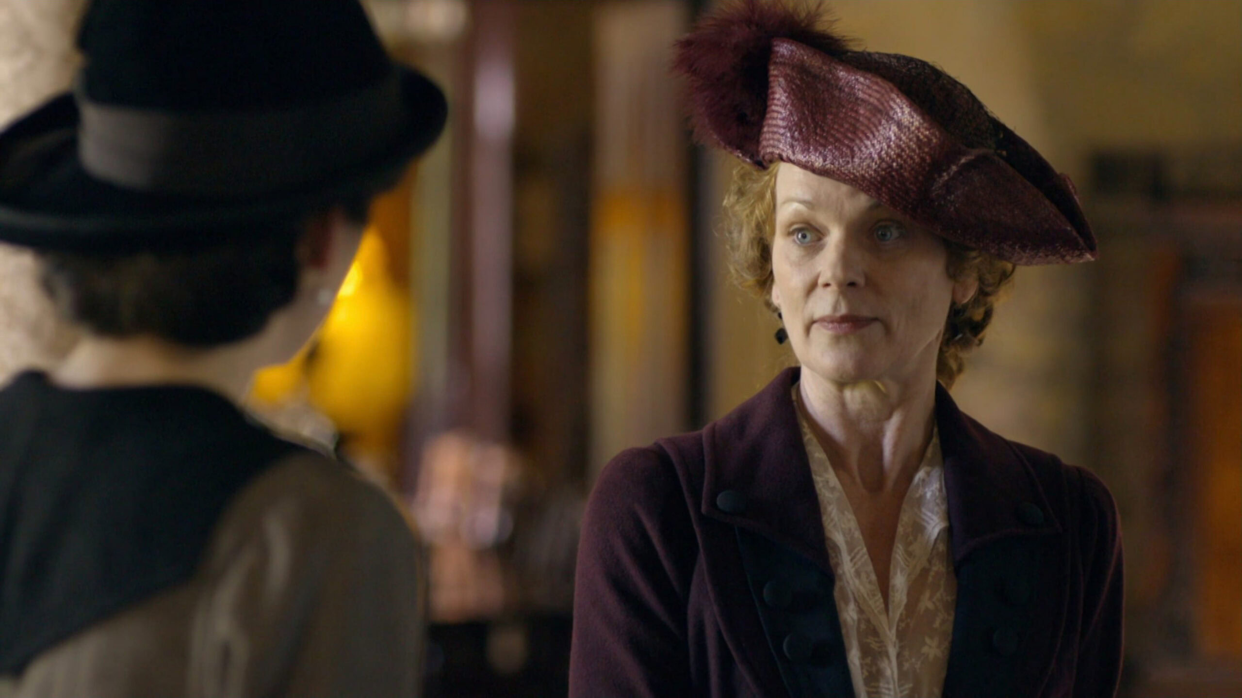 Samantha Bond as Lady Rosamund Painswick wearing a burgundy coat in the 2010 series "Downton Abbey."
