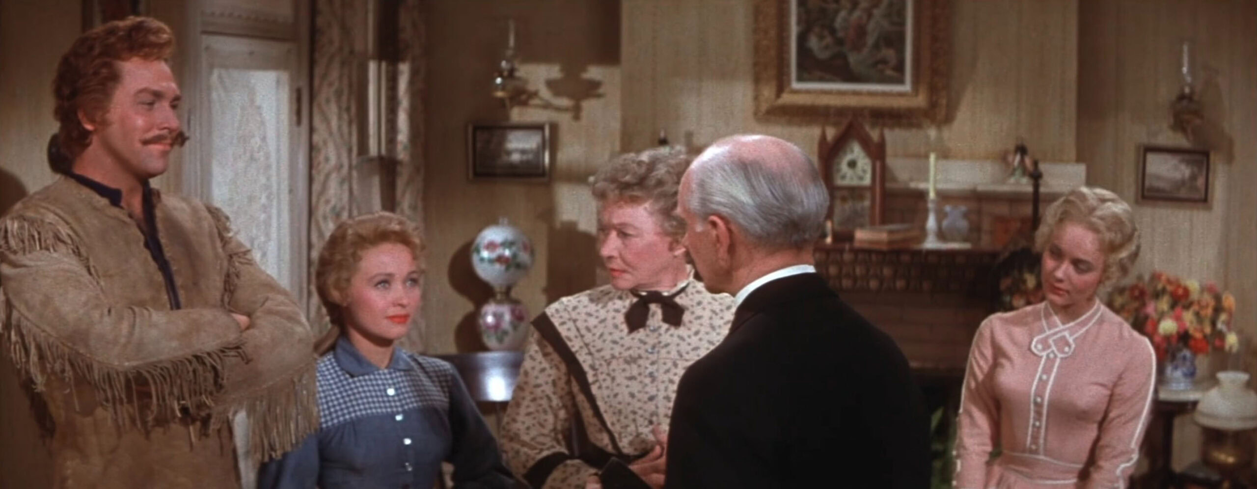 Nancy Kilgas as Alice wearing a pink dress with white detailing in the 1954 film "Seven Brides for Seven Brothers."